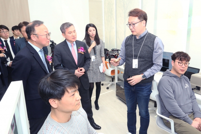 하현회 LG유플러스 부회장(사진 가운데)이 ‘LGU+ 5G 이노베이션 랩’에서 중소기업 직원들의 기술 테스트를 살펴보며 설명을 듣고 있다. [출처=LG유플러스]