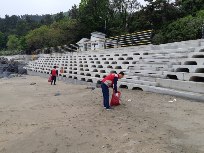 샤롯데봉사단이 여수 신덕해수욕장 해변가 쓰레기를 수거하고 있다. [사진=롯데건설]