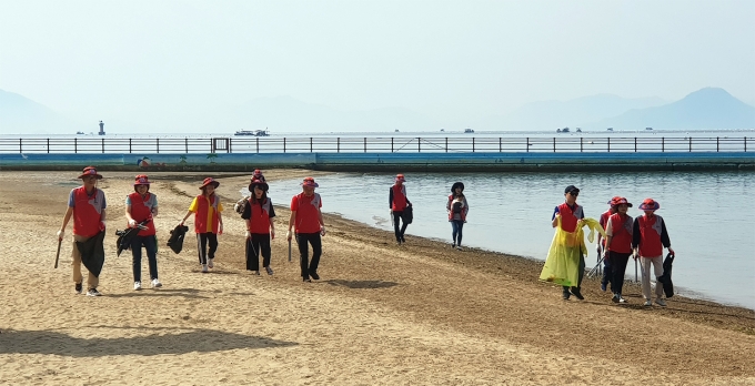 경남은행 임직원들이 해수욕장 환경정화 활동을 벌이고 잇다.[사진=경남은행]