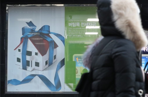 한 시민이 벽에 걸린 전세자금대출 광고를 보고 있다. [사진=뉴시스]