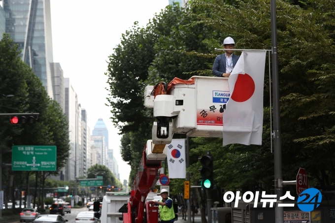 서울 길거리에 걸려 있는 일장기를 걷어내고 있는 모습.  [사진=이영훈 기자]