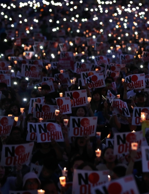 제74주년 광복절인 15일 오후 서울 종로구 광화문광장에서 열린 '역사왜곡·경제침략·평화위협 아베규탄 및 정의평화실현을 위한 범국민 촛불문화제'에서 참가자들이 촛불을 들고 있다. [뉴시스]