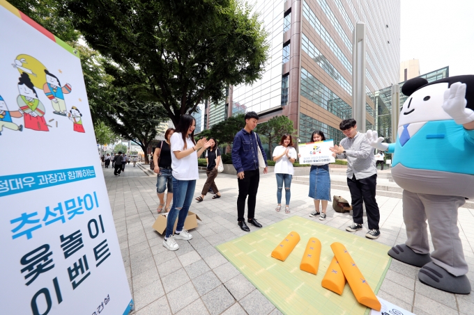지난 9일 광화문을 찾은 시민들이 대우건설 대학생 홍보대사가 마련한 추석맞이 윷놀이 이벤트에 참여하고 있다. [사진=대우건설]