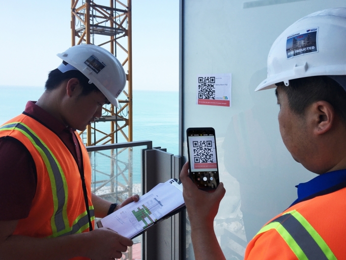 두바이 로얄 아틀란티스 리조트&레지던스 현장 직원들이 건물 벽면에 부착된 QR코드를 통해 실시간 공사 현황을 확인하고 있다. [사진=쌍용건설]