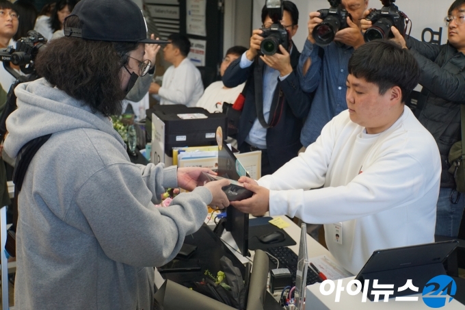 25일 오전 서울 광화문 KT스퀘어에서 KT의 1등 경품인 맥북 프로 등을 받은 고객이 아이폰 개통을 진행하고 있다.