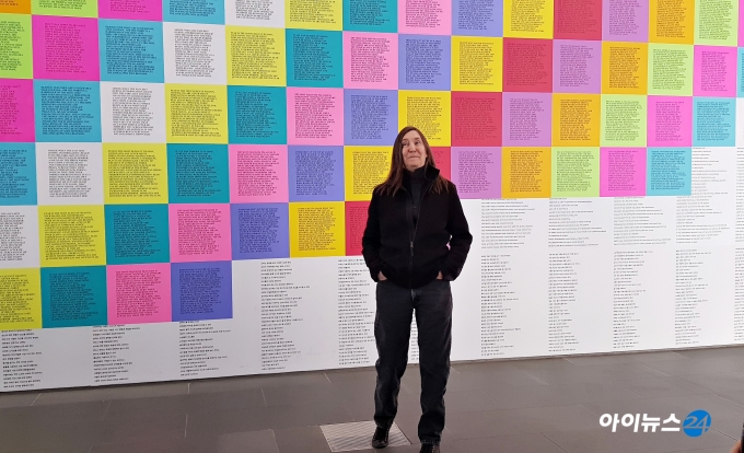 제니 홀저가 국립현대미술관 서울 로비에 설치된 자신의 작품 '경구들' '선동적 에세이' 앞에서 포즈를 취하고 있다.