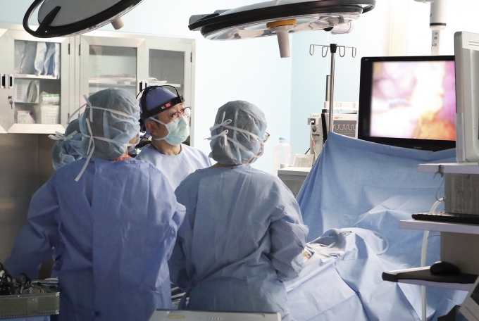 삼성서울병원 의료진이 5G를 사용하는 영상중계장비를 착용하고 수술을 하고 있다. [출처=KT]