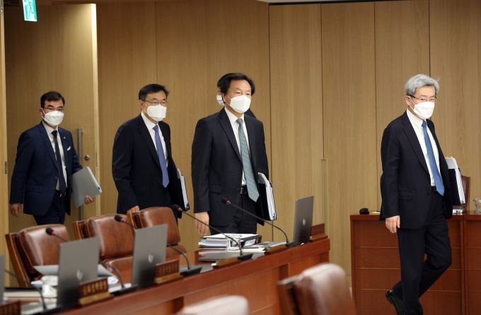 마스크를 낀 금통위원들이 회의실에 입장하고 있다 [사진=한국은행]