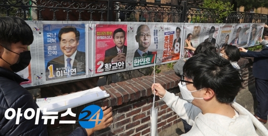 공식 선거운동이 시작된 지난 2일 중앙선관위 직원들이 서울 종로 한 지역에서 선거공보물을 부착하고 있다.  