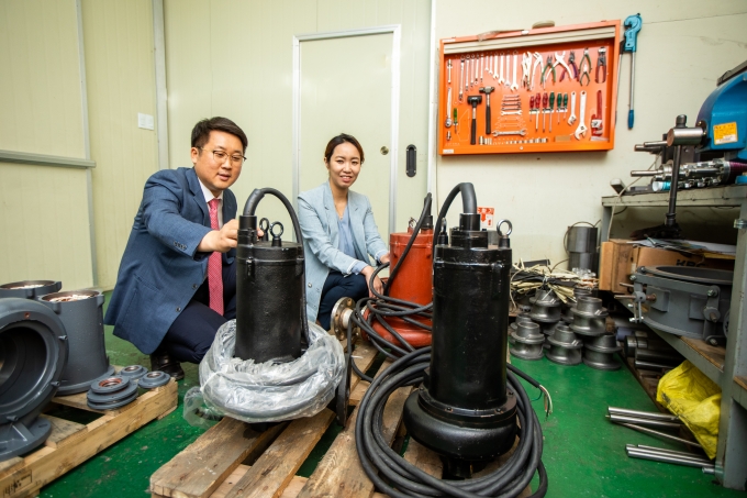 김진혁 박사(좌)와 차미영 황해전기 상무이사(우)가 개발된 단일채널 펌프를 바라보고 있다. [생기원]
