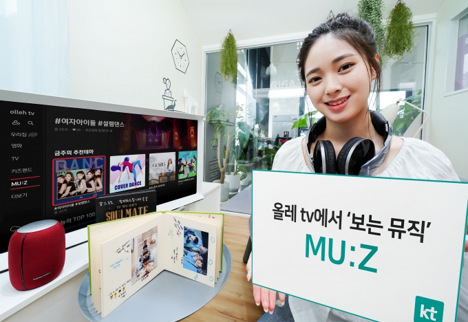 KT 모델이 올레 tv 보는 뮤직 ‘MU:Z’ 서비스를 소개하고 있다 [사진=KT]