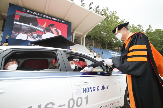 졸업생이 차량에 탑승한 상태로 드라이브 스루(Drive-Thru) 비접촉 형식의 졸업장 수여식을 진행하고 있다. [사진=KT]