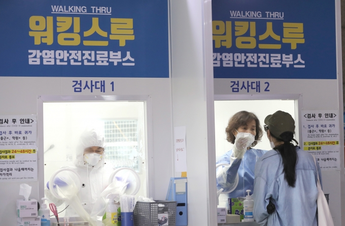 21일 오전 서울 성북구 보건소에 마련된 선별진료소에서 한 시민이 코로나19 검사를 위한 검체를 채취하고 있다. [뉴시스]