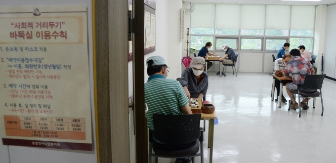 노인복지관에서 어르신들이 마스크를 착용하고 바둑 경기를 즐기고 있다. [뉴시스]