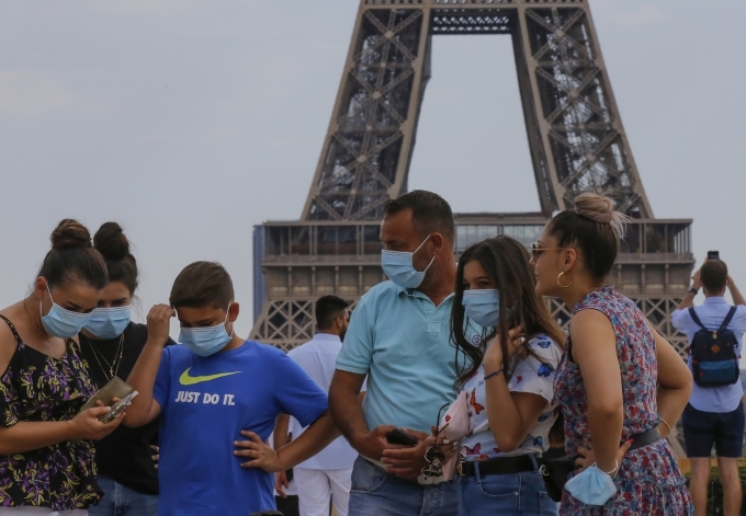 [AP/뉴시스] 파리 에펠탑 앞에서 마스크를 착용한 관광객들이 모여 이야기를 나누고 있다.  [뉴시스]