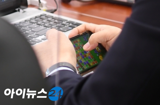 강훈식 더불어민주당 의원이 22일 서울 여의도 국회에서 열린 산업통상자원중소벤처기업위원회의 산업통상자원부에 대한 종합감사에서 국감 도중 자신의 휴대전화로 모바일 게임을 하고 있다.