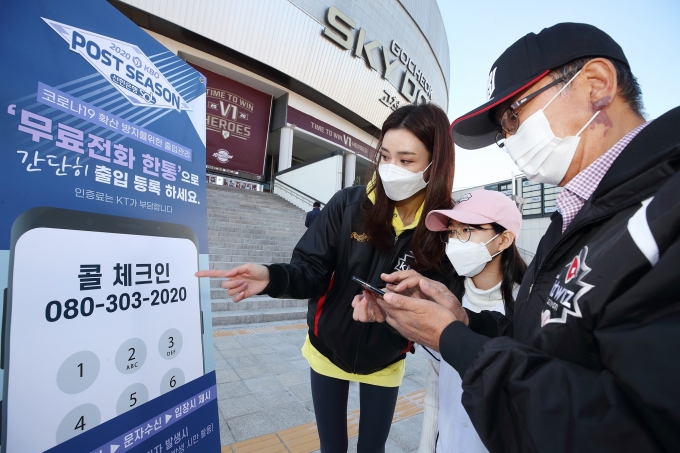 서울 고척스카이돔 입구에서 야구팬들이 KT 080 콜체크인 서비스를 이용해 출입 등록을 하고 있다. [출처=KT]