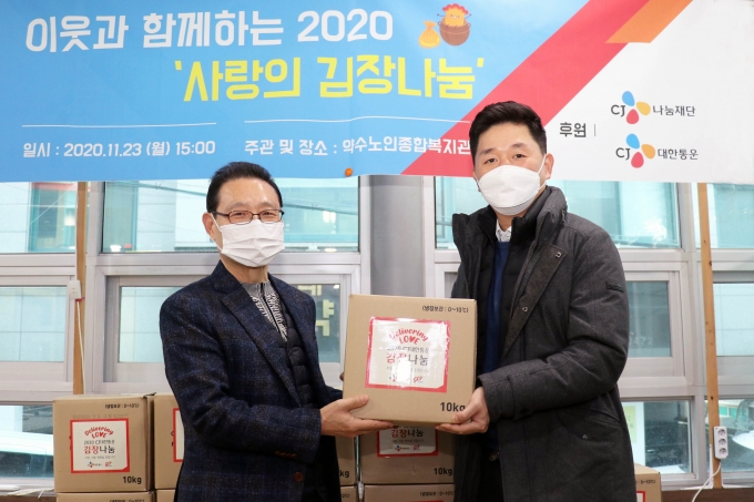 박진규 CJ대한통운 부장(오른쪽)과 민진암 구립약수노인종합복지관장이 '2020 사랑의 김장김치 나누기' 전달식을 가지고 기념 촬영을 하고 있다. [CJ대한통운]