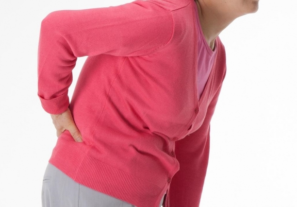 한 중년 여성이 척추관협착증으로 허리 통증을 느끼고 있다. [자생한방병원]