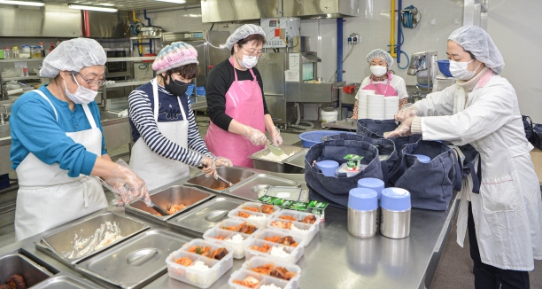 경기도 성남시 하얀마을복지회관 경로식당에서 영양사와 지역 봉사자들이 도시락을 만드는 모습 [사진=SK(주)]
