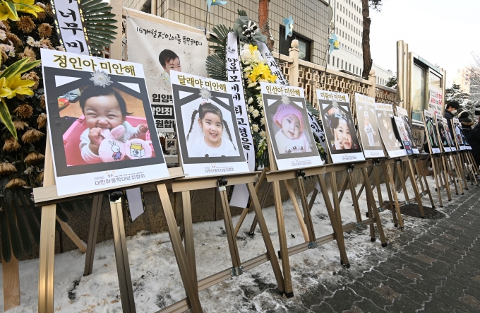 생후 16개월 된 정인이에게 학대해 숨지게 한 혐의를 받는 양부모에 대한 첫 공판이 열린 13일 서울 양천구 남부지방법원 앞에 학대로 숨진 아동들의 사진이 걸려 있다. [사진=조성우 기자]