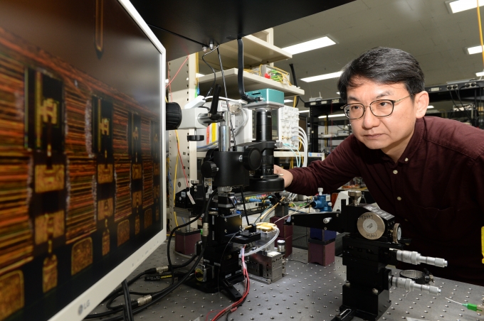 ETRI 한영탁 책임연구원이 400G 광학송수신엔진에 사용된 반도체 광원 칩 살펴보고 있는 모습 [/사진=ETRI]