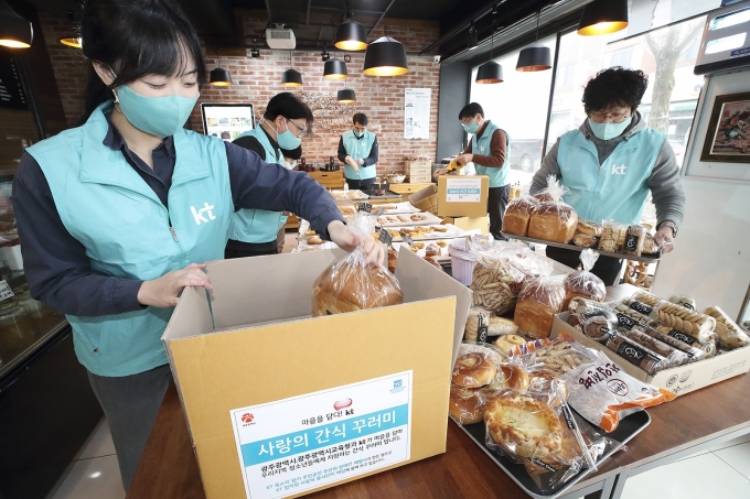 KT 직원들이 광주광역시 남구 '어나더찬 베이커리'에서 '사랑의 간식꾸러미'를 제작하고 있다. [사진=KT]