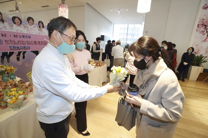 구현모 KT 대표가 광화문에 위치한 KT 이스트 사옥에서 여성 임직원에게 프리지아 꽃을 나눠주고 있다.  [사진=KT]