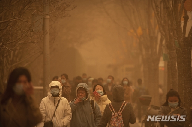15일 중국 베이징에 심각한 황사가 발생한 가운데 거리에 출근하는 시민들이 걸어가고 있다. [뉴시스]
