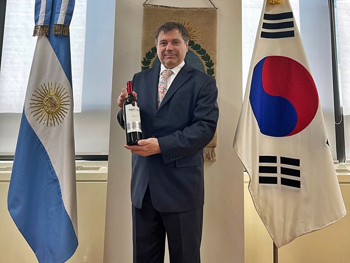 알프레도 카를로스 바스쿠 주한 아르헨티나 대사가 트리벤토 와인을 들고 포즈를 취하고 있다.  [사진=롯데칠성음료]