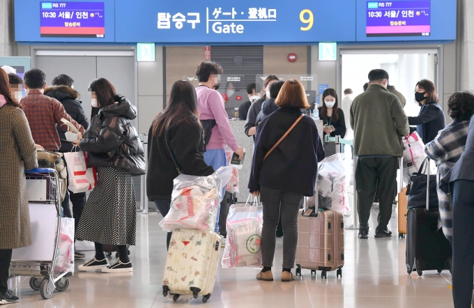 지난 2월 에어서울이 진행한 무착륙 관광비행의 승객들이 면세품을 들고 탑승구로 향하고 있다. [사진=뉴시스]