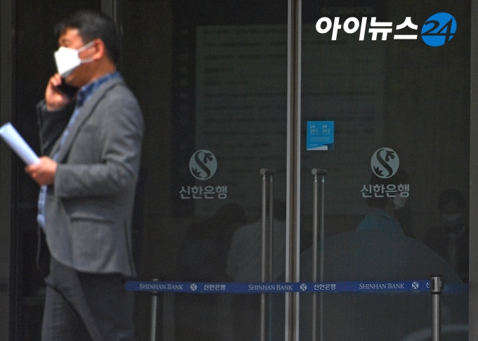 한 시민이 신한은행 본점 앞을 지나가면서 전화통화를 하고 있다.  [사진=아이뉴스24 DB]