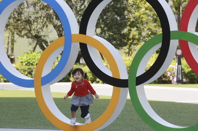 일본 도쿄에서 한 어린이가 올림픽을 상징하는 오륜 조형물에서 놀고 있다. [사진=뉴시스]