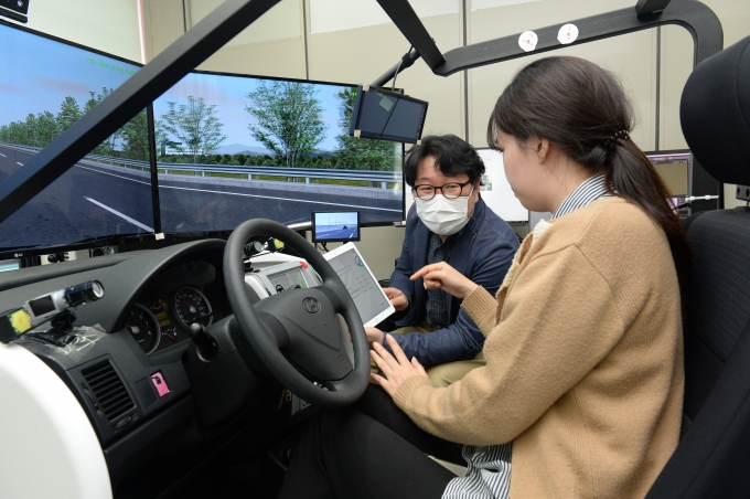 ETRI 연구진이 가상 자동차 실험 환경에서 운전자에게 상황인지 정보 제공 모습 [사진=ETRI]