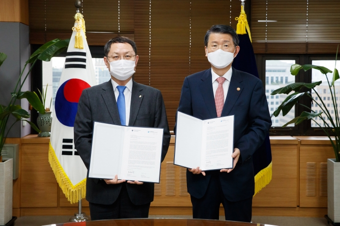 은성수 금융위원장(오른쪽)과 김근익 금융감독원 수석부원장(왼쪽)이 지난 17일 녹색금융협의체(NGFS) 가입 신청 서한에 서명을 하고 있다. [사진=금융위원회 ]