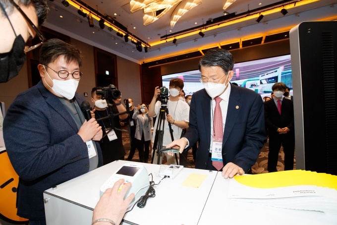 은성수 금융위원장(오른쪽)이 26일 오전 서울 콘래드호텔에서 열린 '코리아 핀테크 위크 2021' 전시장을 체험해보고 있다.  [사진=금융위원회]