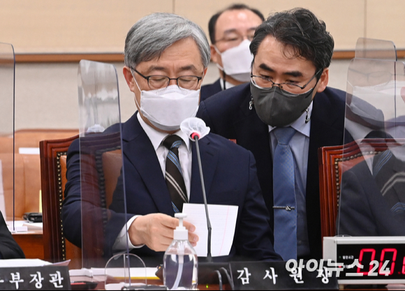 최재형 감사원장이 18일 서울 여의도 국회에서 열린 법제사법위원회에서 의원들의 관계자로부터 자료를 전달받고 있다.
