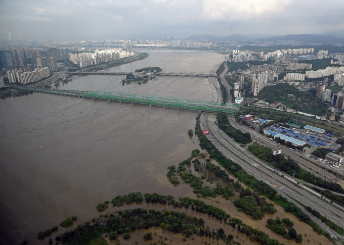 계속된 집중호우로 팔당댐과 소양강댐 방류량이 늘면서 한강대교에 홍수주의보가 발령된 지난해 서울 여의도 63빌딩에서 바라본 한강 모습.