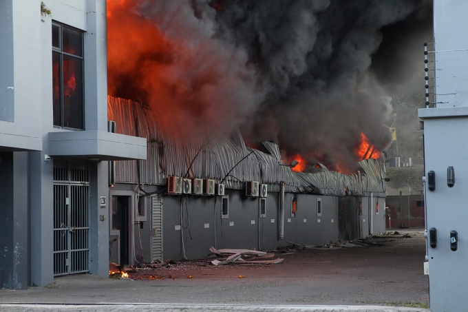 14일(현지시간) 남아프리카공화국 더반 외곽에서 한 공장이 불에 타고 있다. 지난주 제이콥 주마 전 남아공 대통령의 투옥으로 촉발된 폭동과 약탈이 며칠째 이어져 지금까지 72명이 숨진 것으로 나타났다. 경찰은 사망자 대다수가 약탈을 벌이던 중 무질서로 인해 압사했다고 밝혔다. [사진=뉴시스]