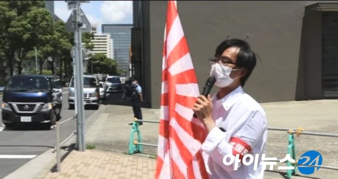 한 극우 단체가 지난 16일 선수촌 앞에서 일본 제국주의 전범기의 상징인 욱일기를 흔들며 도쿄올림픽 선수촌 아파트 한국 선수단 거주층에 내걸린 '이순신 장군' 현수막을 두고 항의하고 있다. [사진=유튜브 영상 캡처]