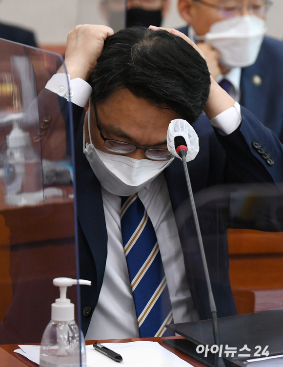 김진욱 고위공직자범죄수사처장이 22일 서울 여의도 국회에서 열린 법제사법위원회 전체회의에 참석해 머리를 쓸어 넘기고 있다.