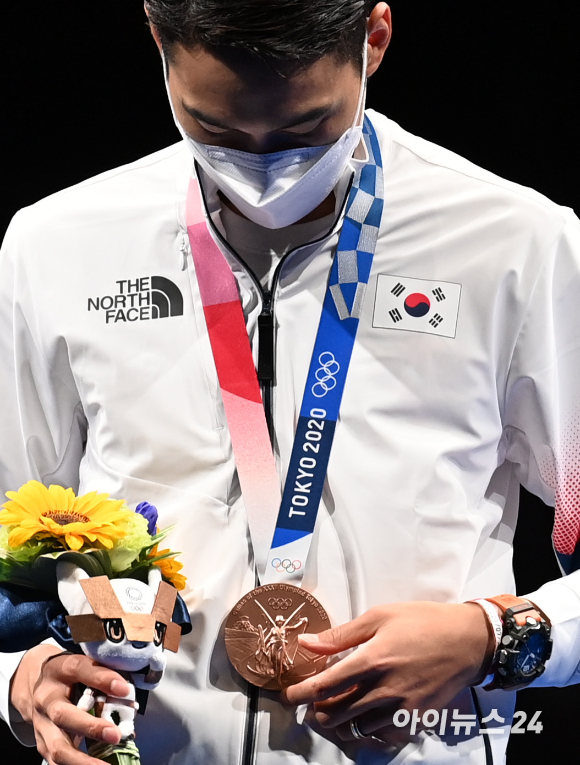 대한민국 펜싱 김정환이 24일 일본 지바 마쿠하리 메세홀에서 열린 '2020 도쿄올림픽' 남자 사브르 시상식에서 자신의 동메달을 바라보고 있다.  