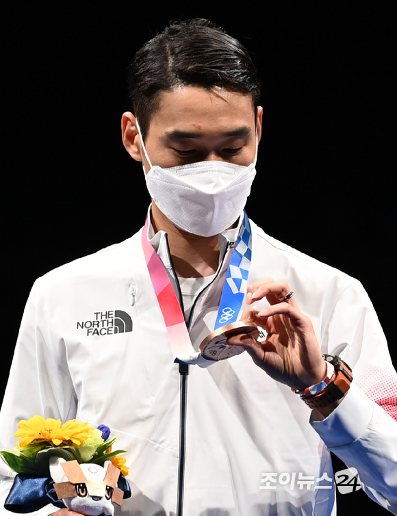 대한민국 펜싱 김정환이 24일 일본 지바 마쿠하리 메세홀에서 열린 '2020 도쿄올림픽' 남자 사브르 시상식에서 동메달을 살펴보고 있다.