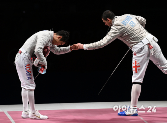 대한민국 펜싱 김정환이 24일 일본 지바 마쿠하리 메세홀에서 열림 '2020 도쿄올림픽' 남자 사브르 개인 동메달 결정전에서 승리한 후 상대 선수 조지아 산드로 바자제와 인사하고 있다.