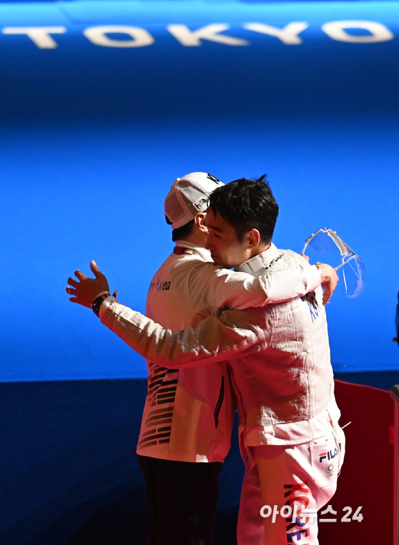 대한민국 펜싱 김정환이 24일 일본 지바 마쿠하리 메세홀에서 열린 '2020 도쿄올림픽' 남자 사브르 개인 동메달 결정전에서 승리한 후 코칭 스태프와 포옹을 하고 있다.