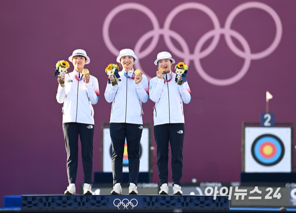 대한민국 양궁 국가대표 안산, 장민희, 강채영이 25일 일본 유메노시마 공원 양궁장에서 열린 2020 도쿄올림픽 여자 양궁 단체 결승전에서 금메달을 따낸 후 기념촬영을 하고 있다. 한국 여자 양궁은 단체전 9연패 위업을 달성했다. [사진=정소희 기자]