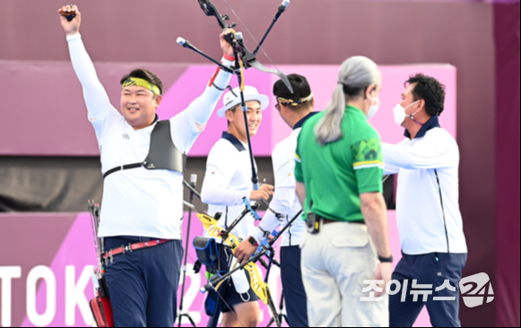 양궁 국가대표 김제덕, 김우진, 오진혁이 26일 오후 일본 도쿄 유메노시마 공원 양궁장에서 열린 2020 도쿄올림픽 남자양궁 단체전 대만과의 결승전에서 금메달을 따낸 후 기뻐하고 있다.