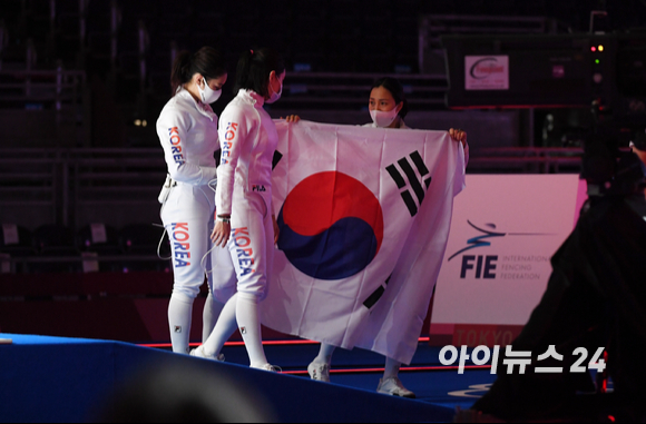 한국 펜싱 최인정, 강영미, 송세라, 이혜인이 2020 도쿄올림픽 펜싱 여자 에페 단체전 결승전 대한민국과 에스토니아의 경기에서 은메달을 따낸 후 태극기를 들고 세리머니를 하고 있다.