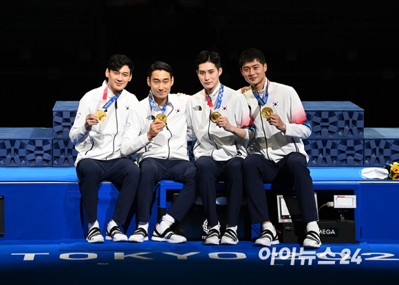 한국 펜싱 남자 대표팀(오상욱·구본길·김정환·김준호)이 28일 일본 지바의 마쿠하리 메세홀B에서 열린 2020 도쿄올림픽 남자 사브르 단체전 결승에서 이탈리아를 45-26으로 제압하고 금메달을 차지했다. 선수들이 시상식에서 금메달을 들고 기념사진을 촬영하고 있다.