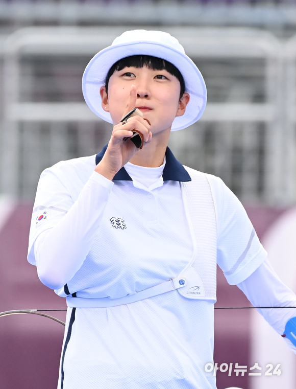 한국 양궁 안산이 30일 일본 도쿄 유메노시마공원 양궁장에서 열린 2020 도쿄올림픽 양궁 여자 개인전 준결승에서 미국의 M.브라운을 제압하고 결승에 진출했다. 경기 중 한국 선수단의 열정적인 응원에 미소 지으며 손가락 제스쳐를 보내는 안산의 모습.